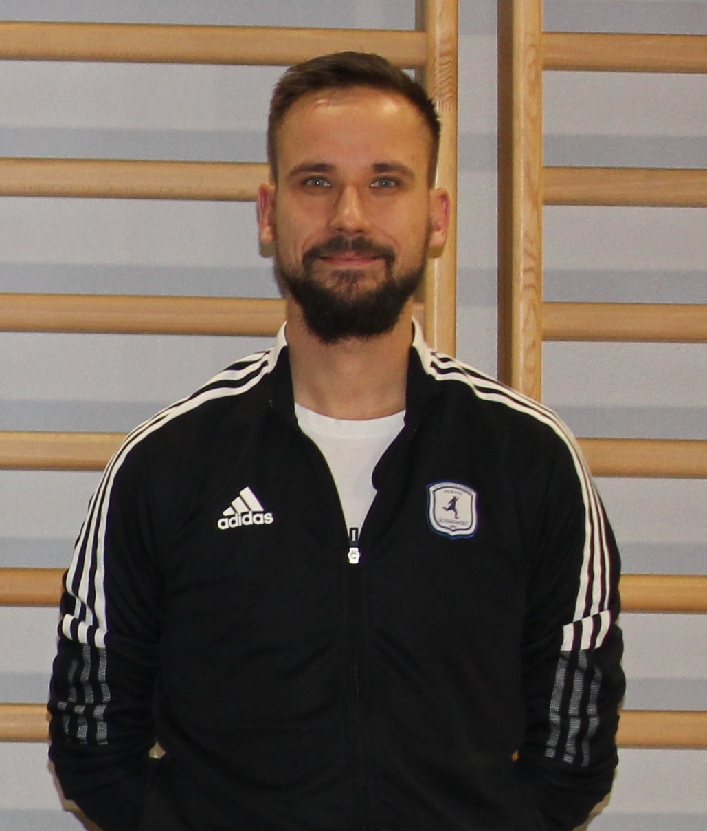 Mężczyzna w czarnej bluzie adidas z logo klubu sportowego